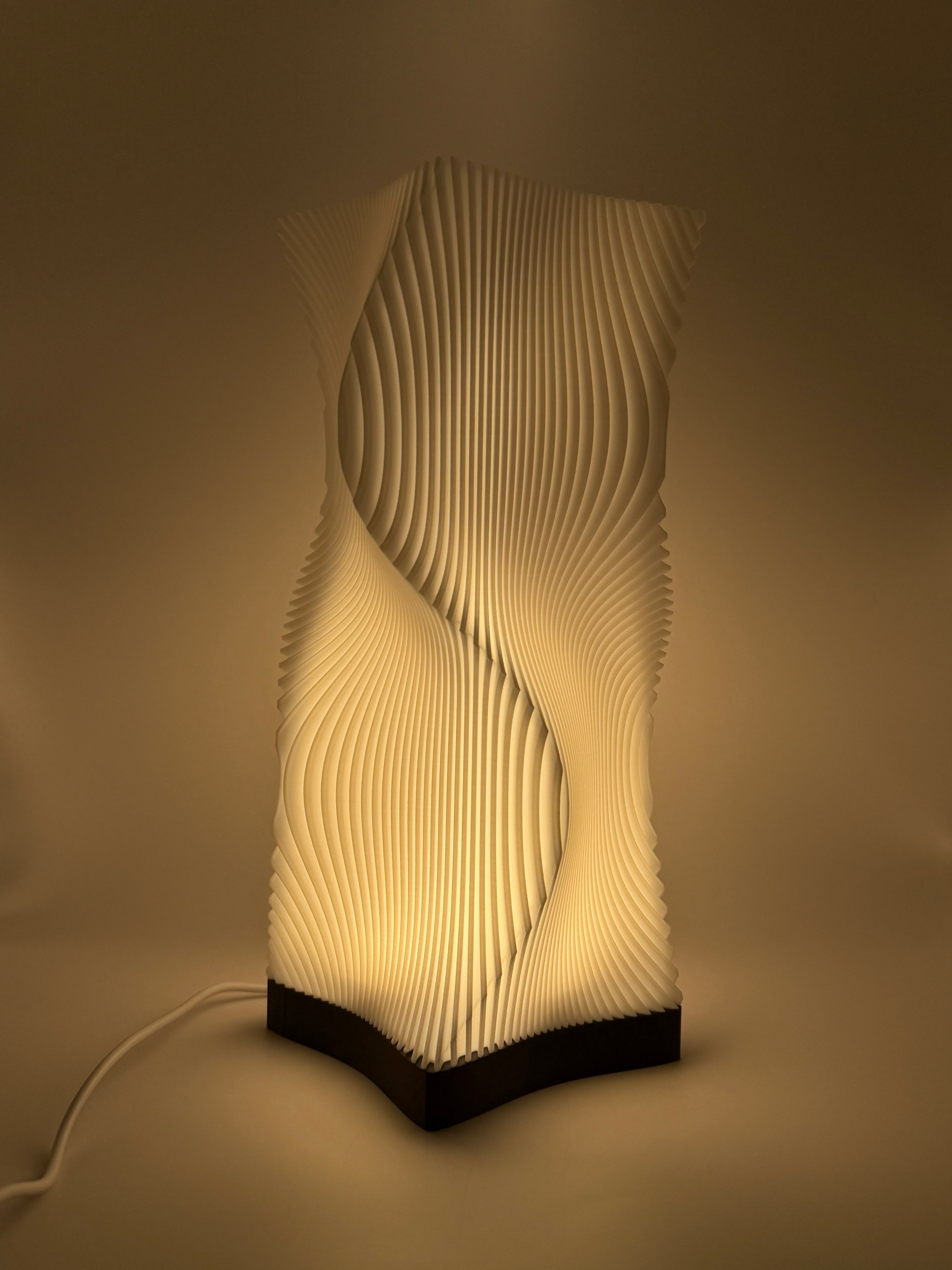 Moderne weiße Lampe mit 3D-gedruckter, wellenförmiger Lamellenstruktur, die ein indirektes Licht  wirft.